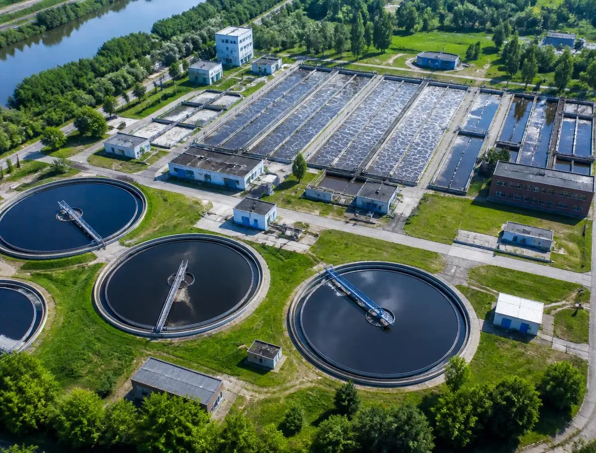 Aerial view of a municipal sewage treatment plant with circular clarifiers and aeration basins